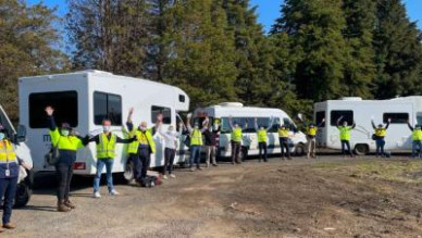 Photo of team standing in front of 3 campervans