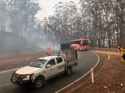 Bushfire response team in the middle of a still smoking road